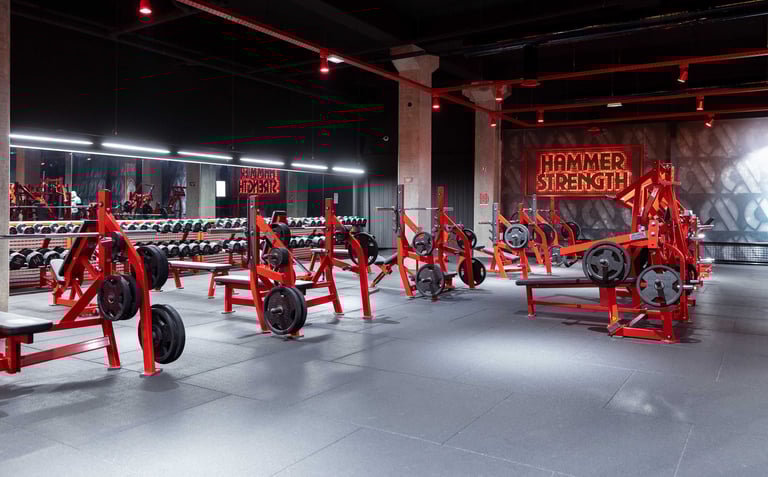 A showroom displaying red agricultural machinery and farm equipment under warm industrial lighting