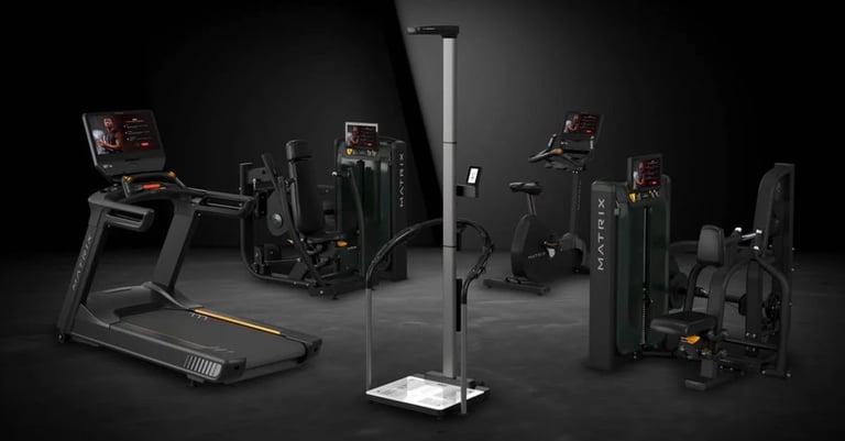 Collection of black fitness equipment including treadmill, exercise bikes, and strength training machines arranged on dark background